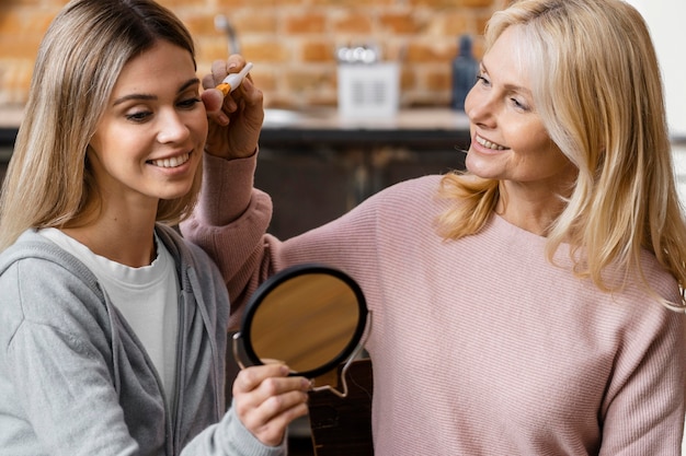 Улыбающиеся женщины дома с помощью кисти для макияжа