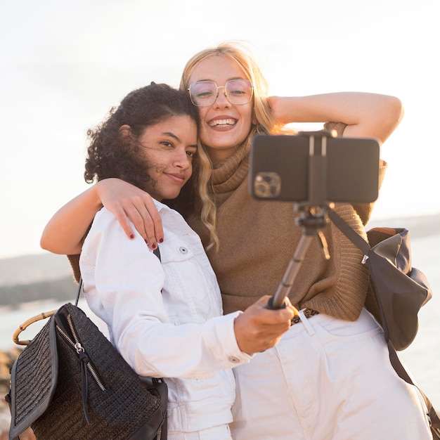 Free photo smiley women taking selfie together