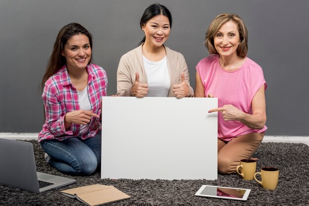 Free photo smiley women with blank paper sheet