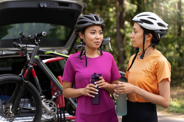 Free photo smiley women with helmets side view