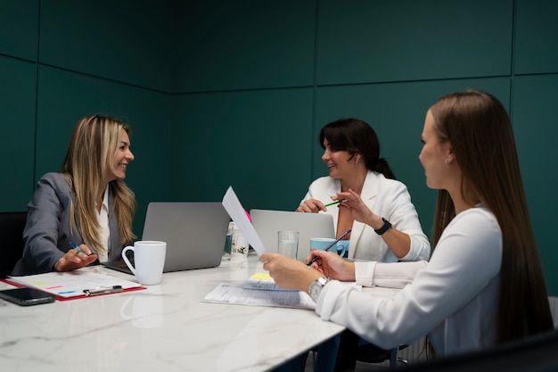 Foto gratuita donne sorridenti che lavorano insieme vista laterale