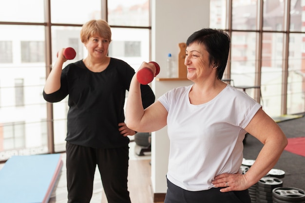 Free photo smiley women working with weights