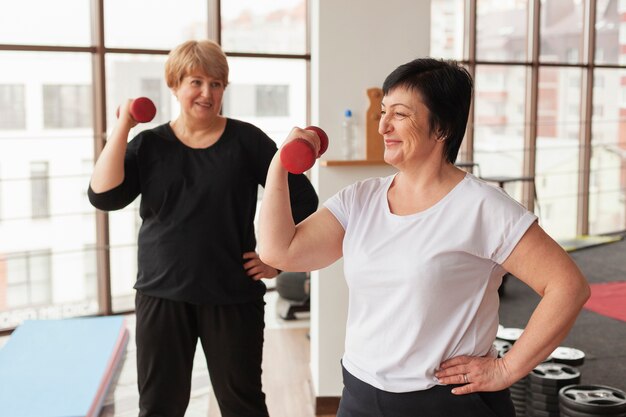 Smiley women working with weights