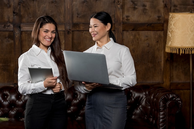 Smiley womens looking at laptop