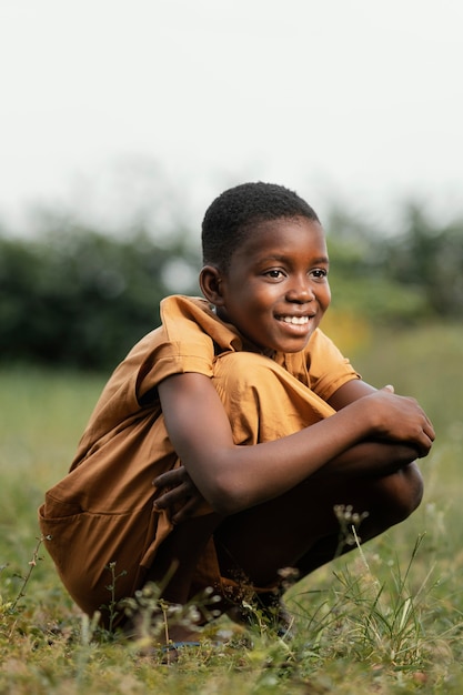 Smiley young african boy standing in field