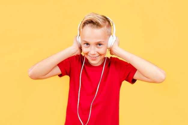 Free photo smiley young boy listening music