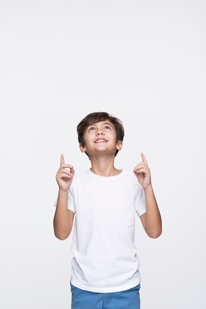 Smiley young boy pointing up