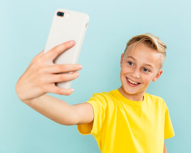 Smiley young boy taking selfies