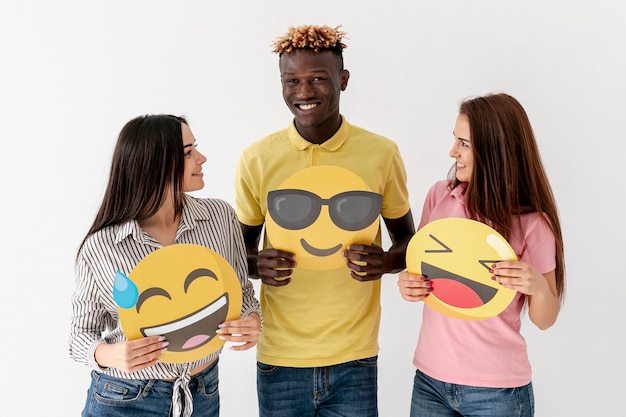 Smiley young friends holding emoji