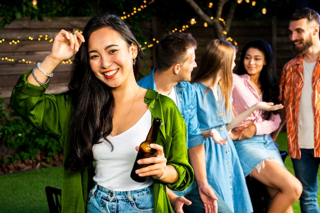 Smiley young girl holding beer bottle