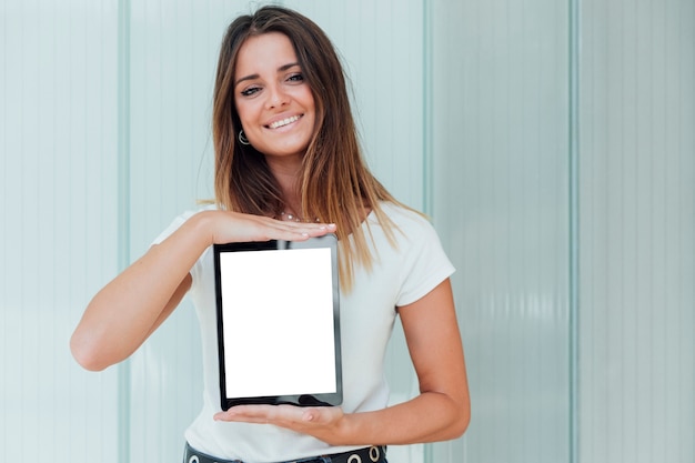 Free photo smiley young girl holding tablet