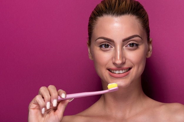 Free photo smiley young girl holding toothbrush