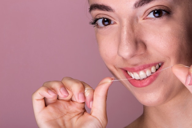 Free photo smiley young girl using floss