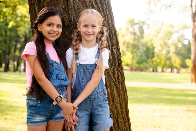 Smiley young girlfriends holding hands