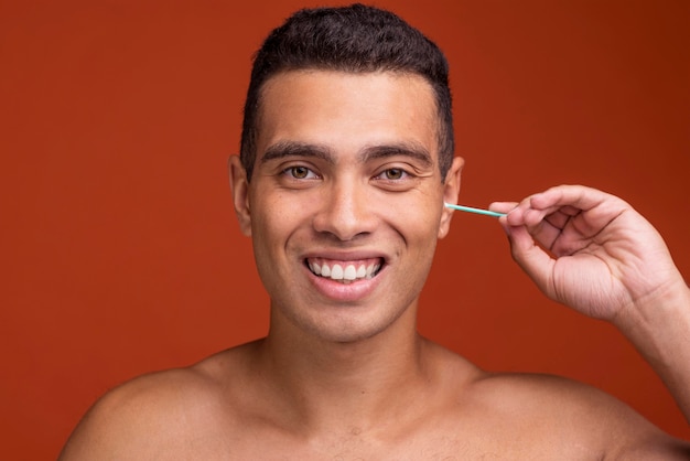 Бесплатное фото Смайлик молодой мужчина, используя ушные палочки