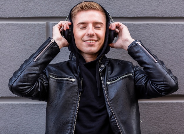 Free photo smiley young man listening to music on headphones
