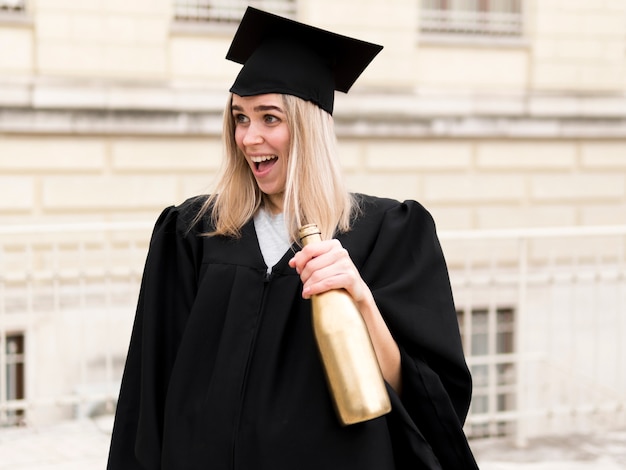 Smiley young woman in graduation gown