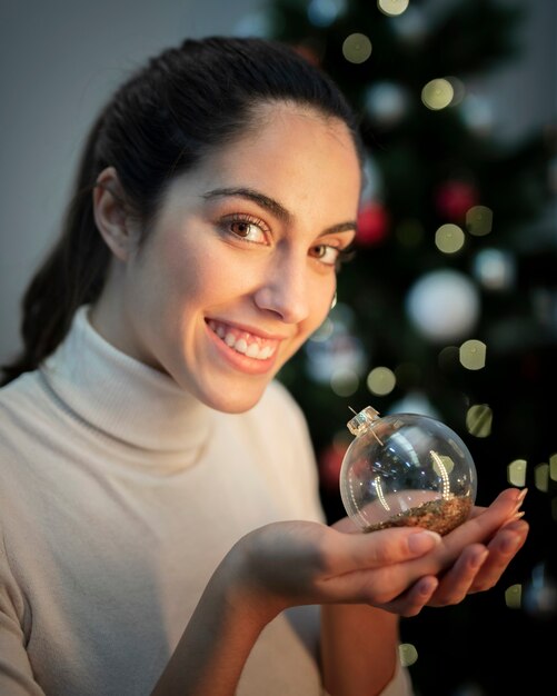 クリスマスグローブを保持しているスマイリーの若い女性