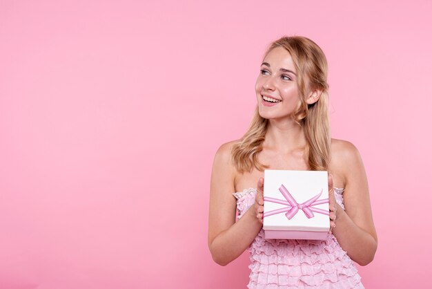 Smiley young woman holding gift