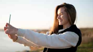 Foto gratuita giovane donna di smiley che cattura un selfie