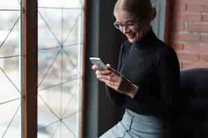 Free photo smiley young woman using phone