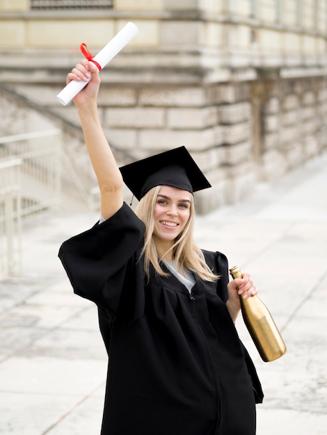 Smiley young woman wearing graduation gown