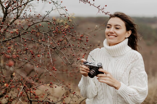Smiley young woman with camera