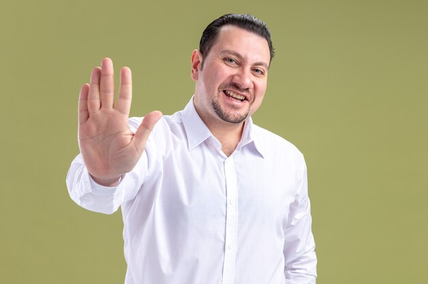 Smiling adult slavic businessman keeping his hand open 