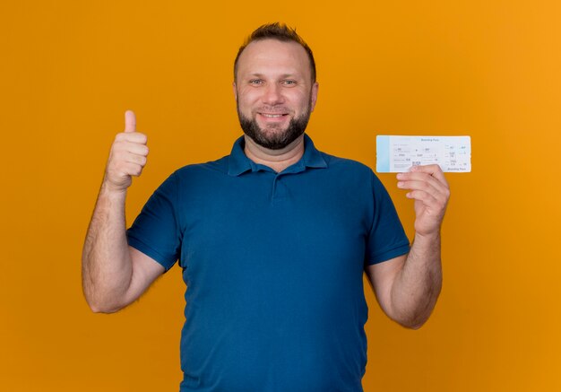 Smiling adult slavic man holding travel ticket looking showing thumb up