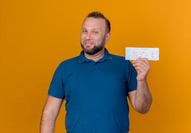 Smiling adult slavic man holding travel ticket looking