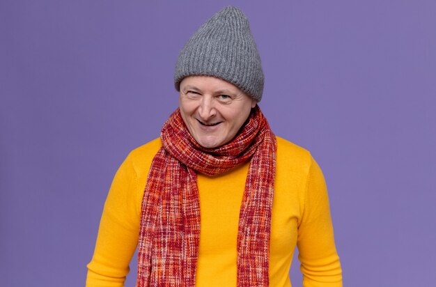 Smiling adult slavic man with winter hat and scarf around his neck 
