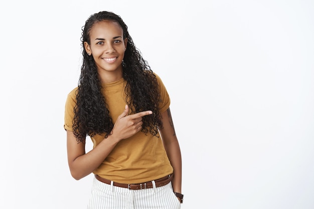 Smiling African-American girl pointing to the right