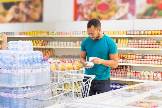 Smiling African American man taking products from freezer