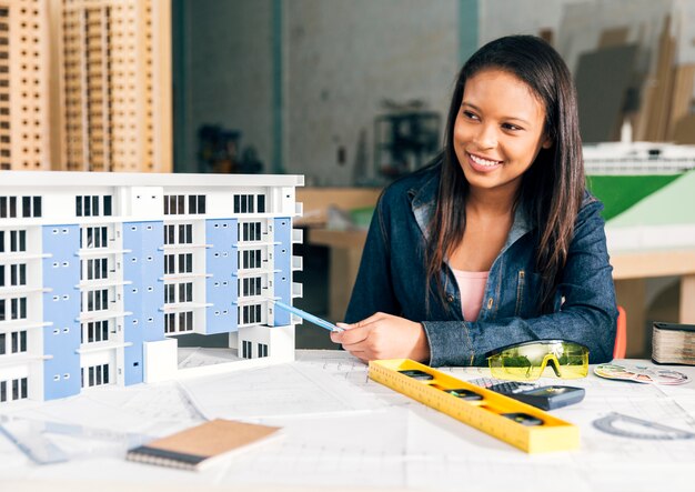 Smiling African-American woman showing model of building