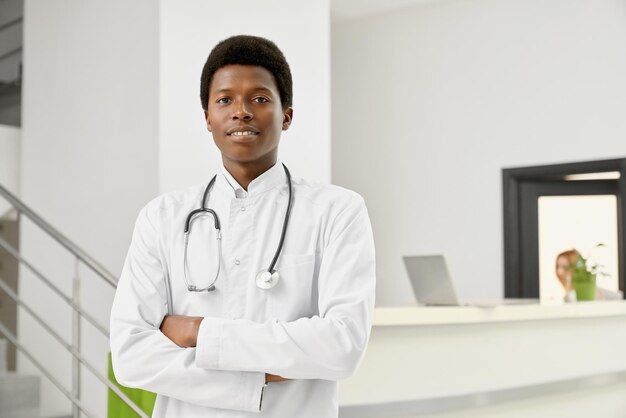 Smiling african doctor in coat with arms crossed