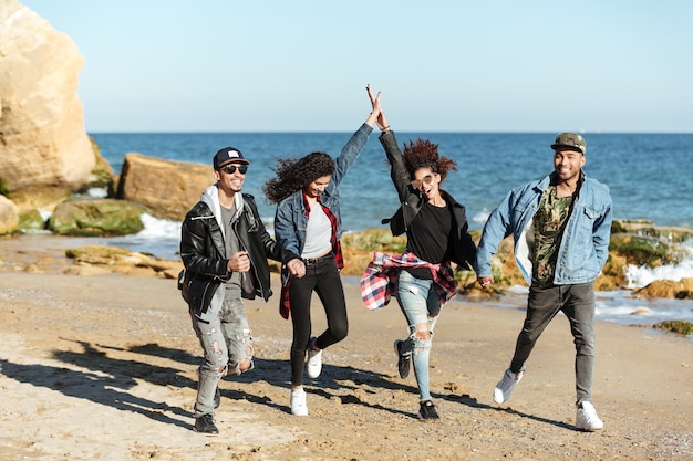 Foto gratuita amici africani sorridenti che camminano all'aperto alla spiaggia.