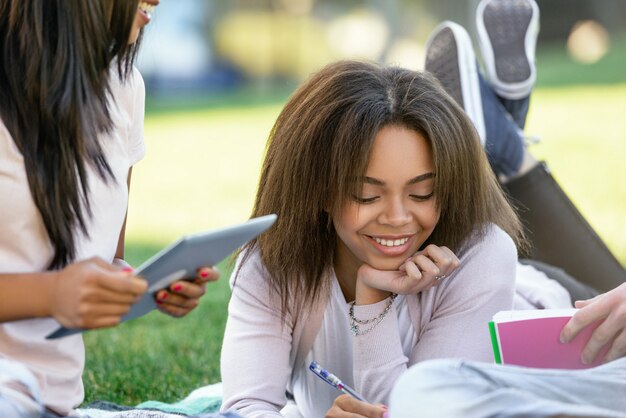 屋外勉強してアフリカの女性学生を笑顔