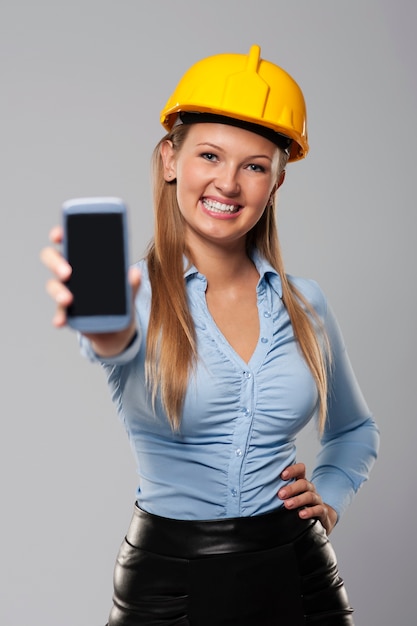 Smiling architect woman showing screen of smart phone