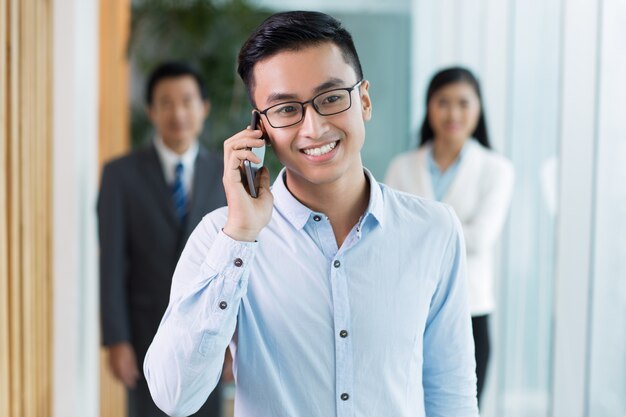 Smiling Asian businessman talking on mobile phone