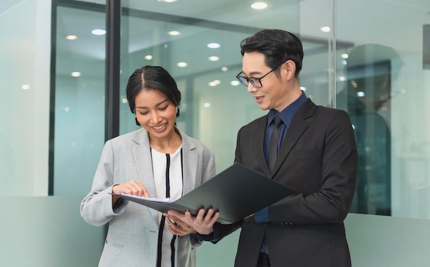 Free photo smiling asian businesswoman showing document report to her manager during a meeting in the office