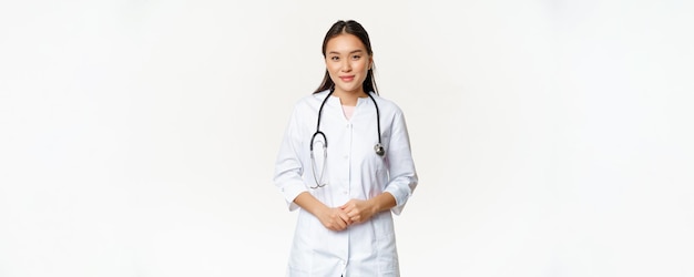환자 스탠에서 도움이 되는 의사 유니폼을 입고 청진기와 웃는 아시아 의료 노동자