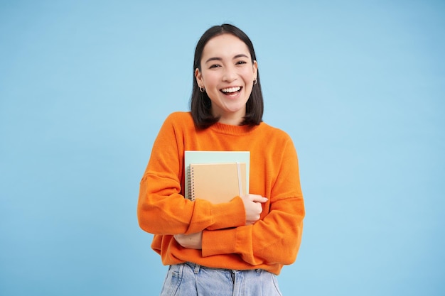 무료 사진 대학 교육 블루 backgroun의 행복 한 얼굴 프로모션 노트북 학생과 웃는 아시아 여자