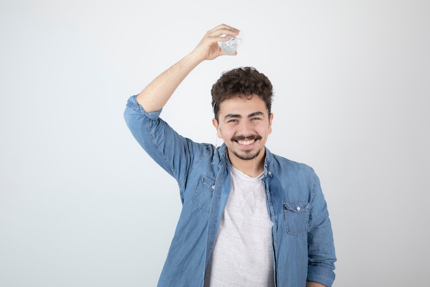 smiling attractive man standing and holding a glass jar.