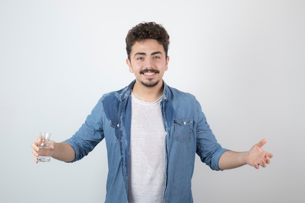 smiling attractive man standing and holding a glass jar.