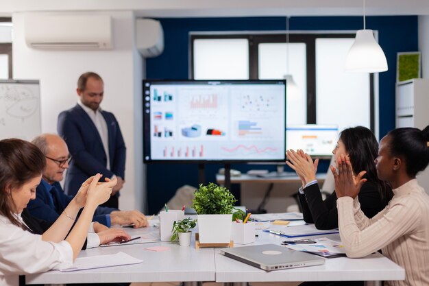 Smiling audience applauding at a business seminar after speaker couch presenting