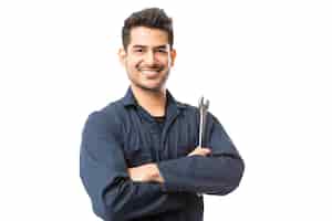 Free photo smiling auto mechanic with wrench standing hands folded on white background