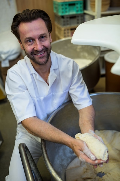 Free photo smiling baker preparing dough