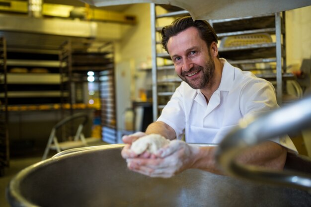 Smiling baker preparing dough