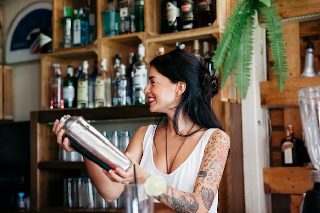 Smiling bartender making cocktail