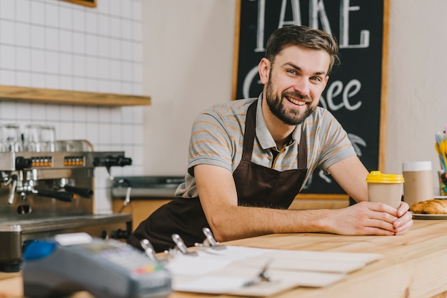 Barista sorridente con bevanda calda